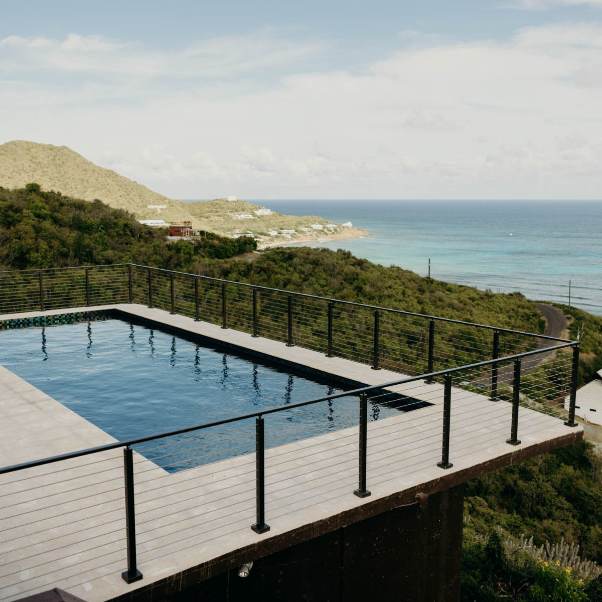 Viewrail Signature Cable Railing surrounds a large pool which overlooks the ocean in the Virgin Islands.