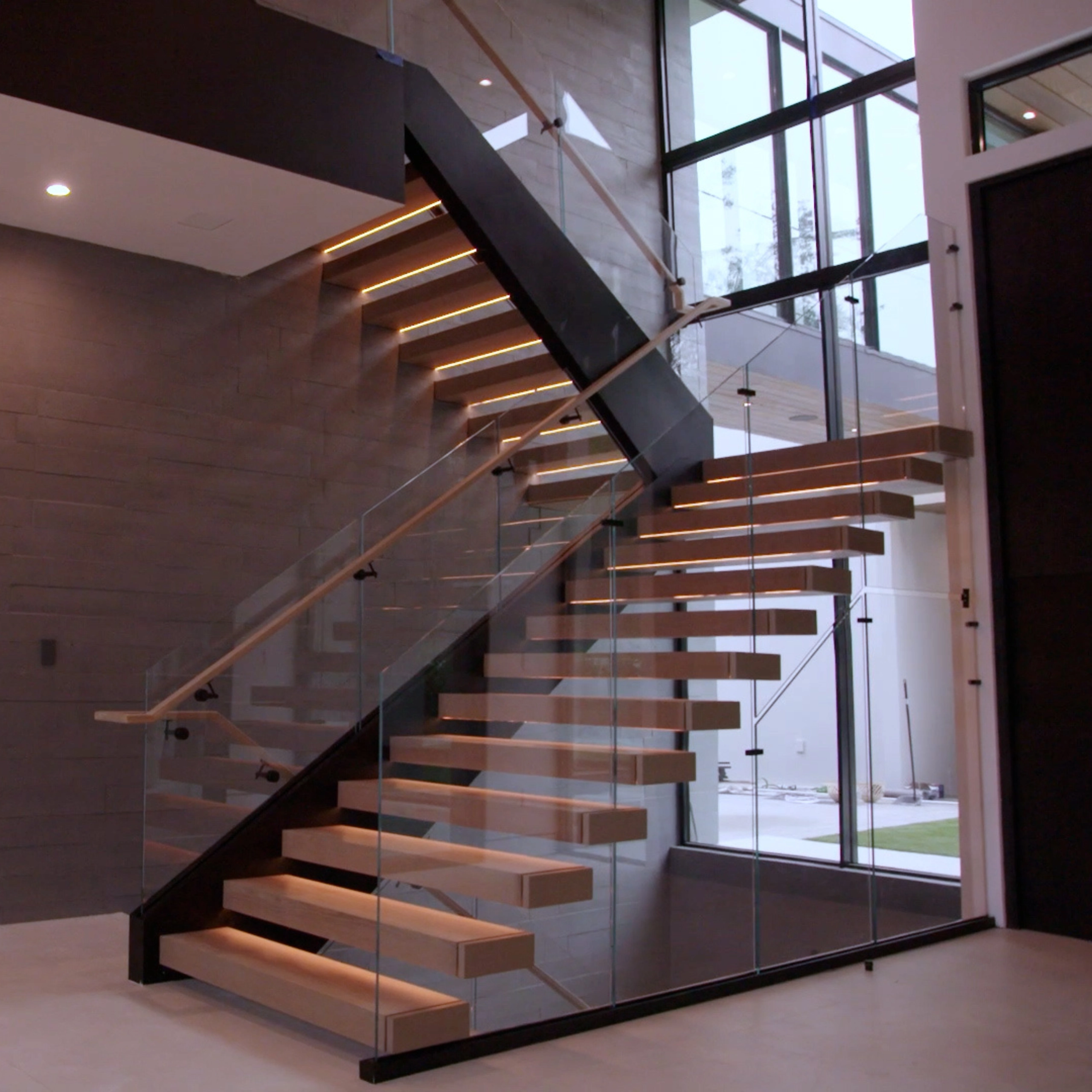 Side view of the FLIGHT Blade stair system with Vedera Glass Railing