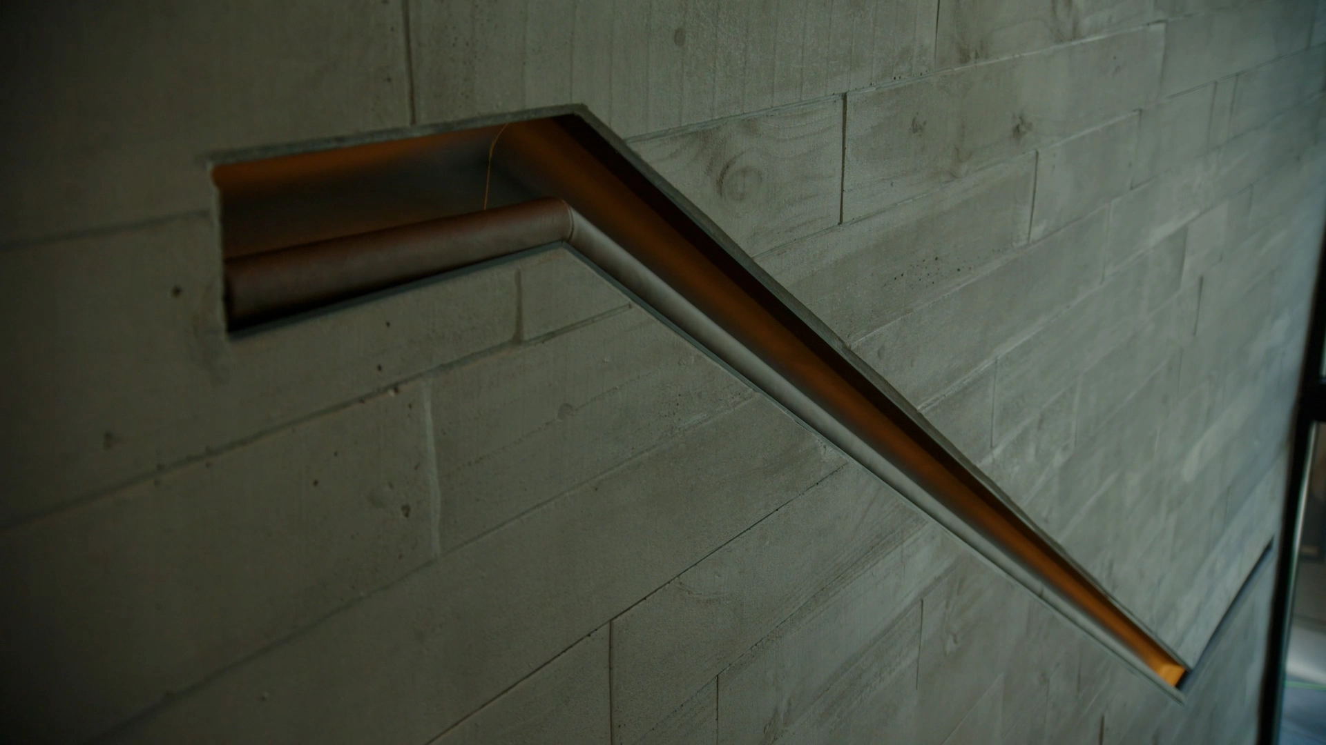 Recessed, leather-wrapped handrail on the wall opposite the FLIGHT Blade stair system.