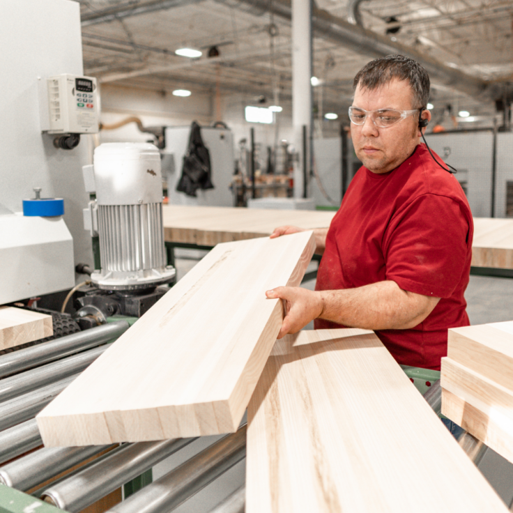 A Viewrail employee handles wood in the tread-making process.