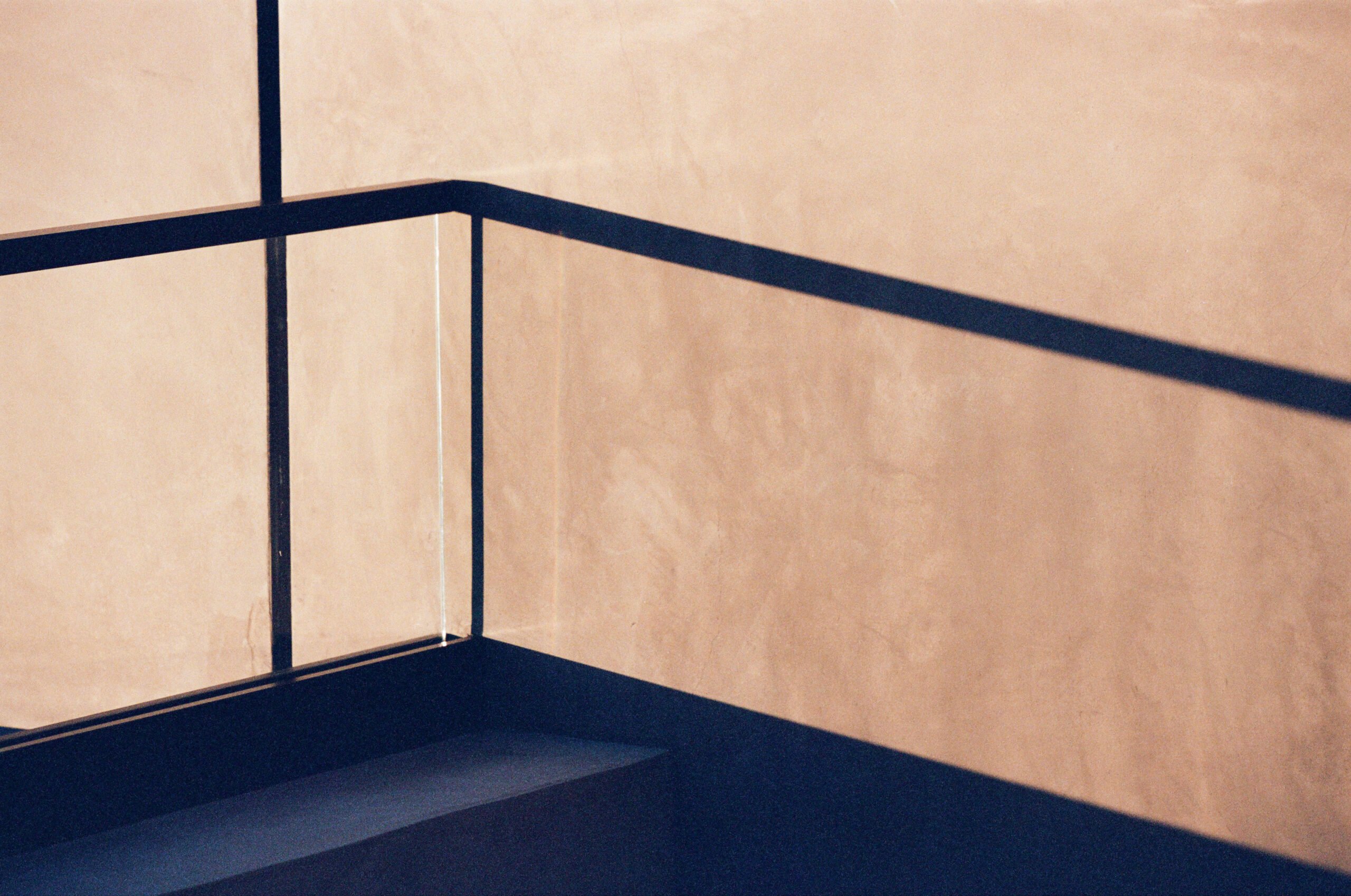 A view of a glass railing casting a long shadow.