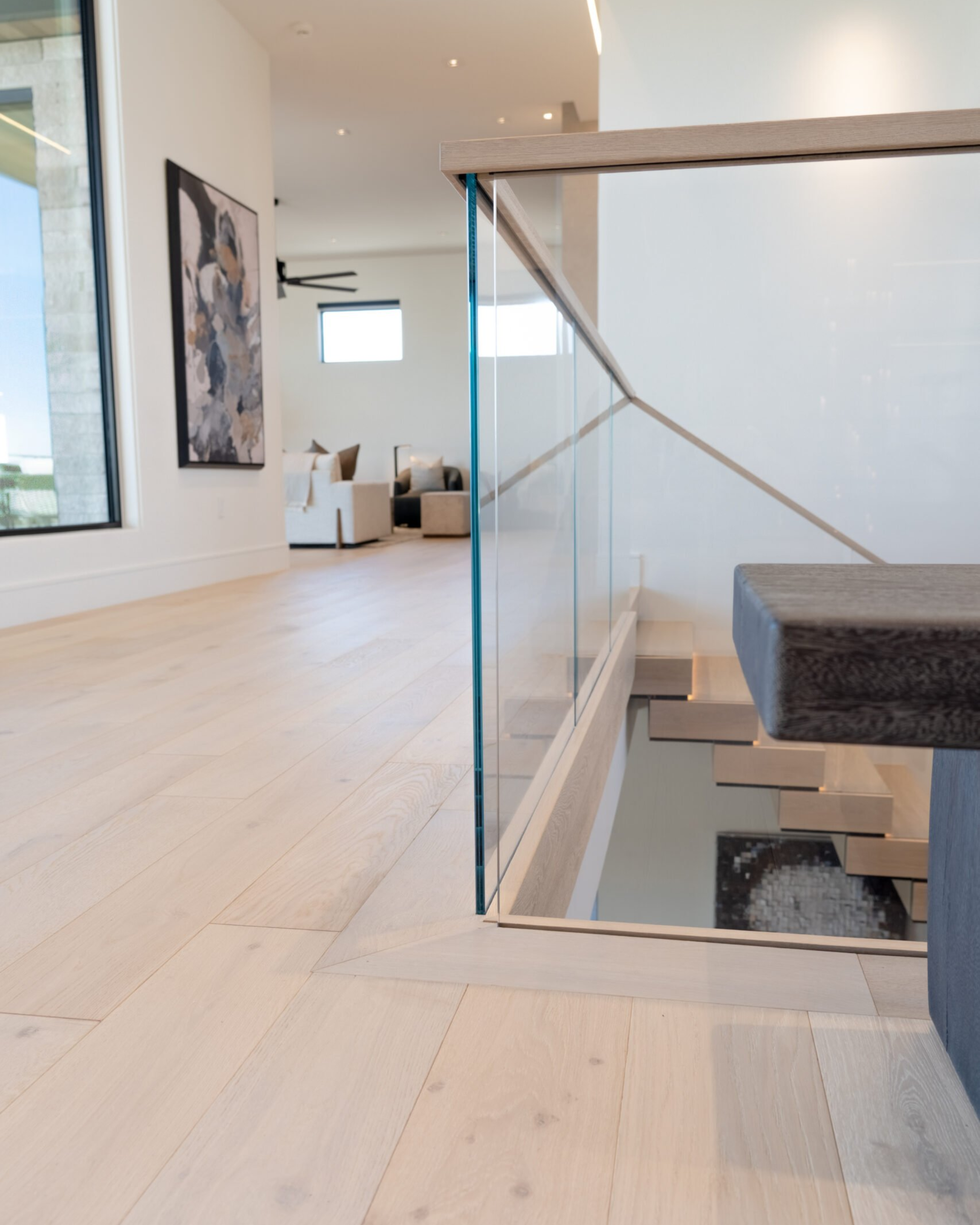 A Hidden Side Mount glass railing system sits at the top of the stairs in a modern home.