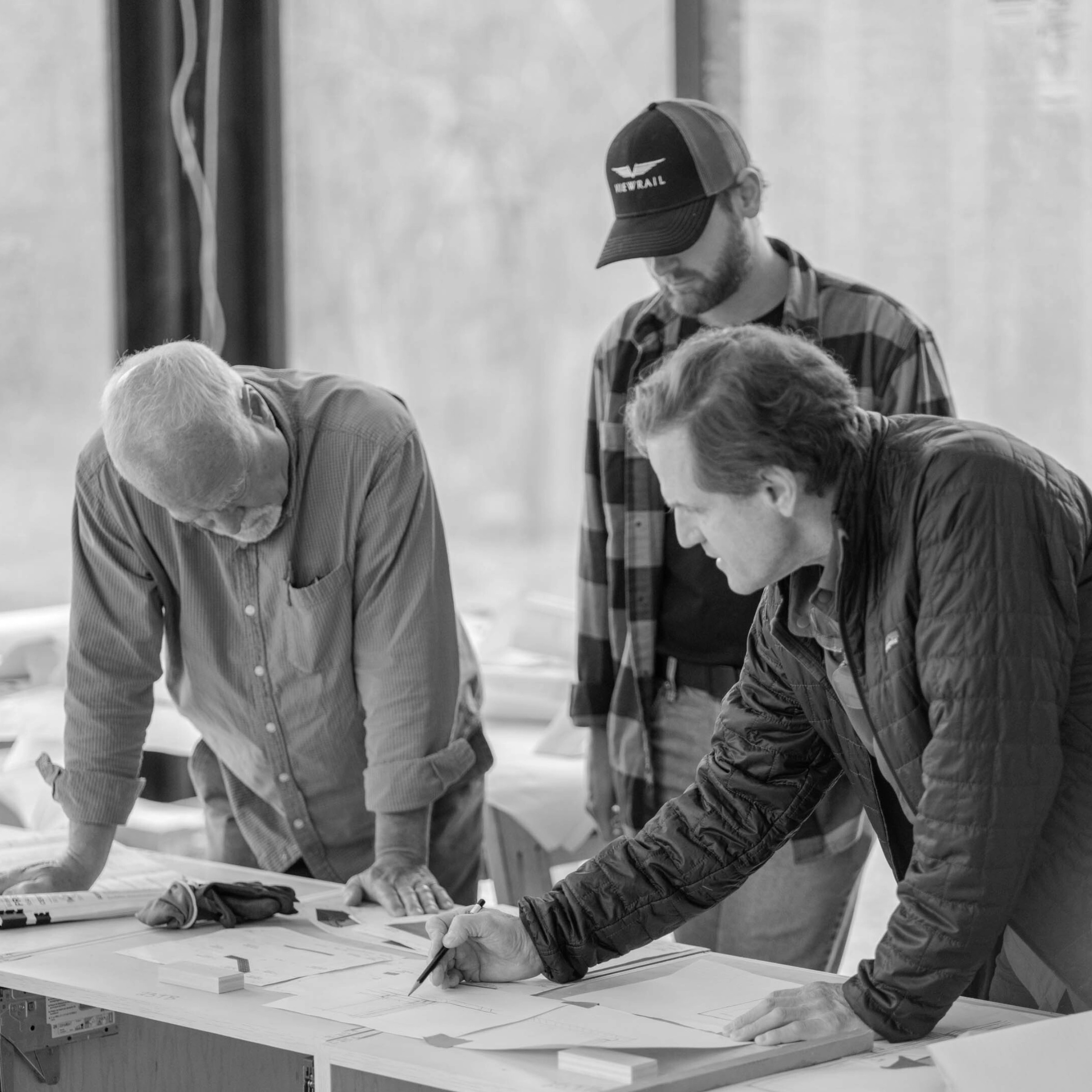 Three certified installers look over blueprints at a job site.