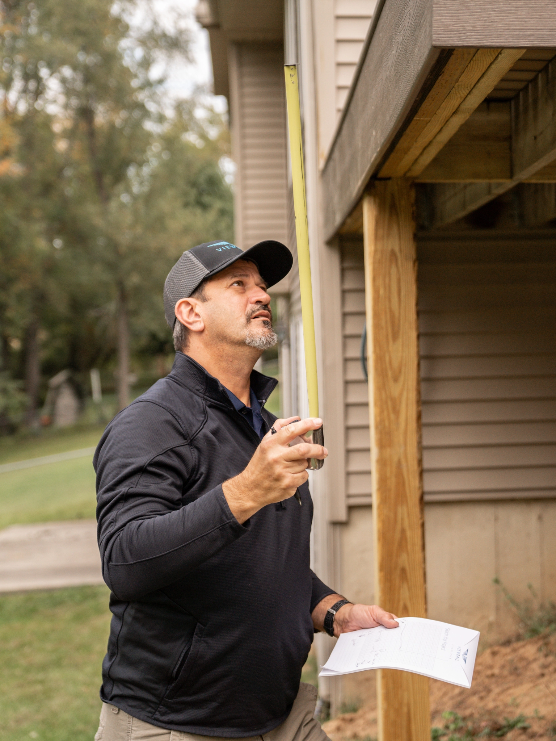 A certified installer measures an outdoor deck for a FLIGHT system installation